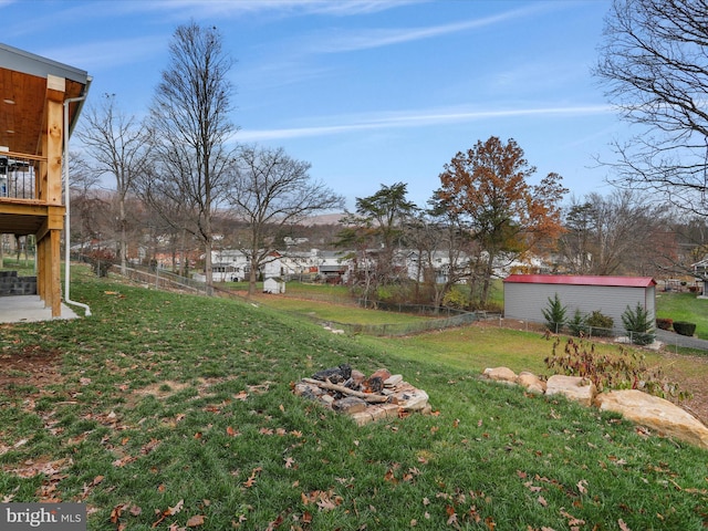 view of yard with a fire pit and an outdoor structure