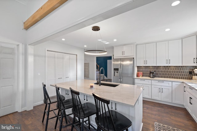 kitchen with stainless steel fridge with ice dispenser, a center island with sink, dark hardwood / wood-style floors, and sink