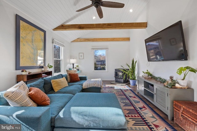 living room with a wood stove, lofted ceiling with beams, ceiling fan, and dark wood-type flooring