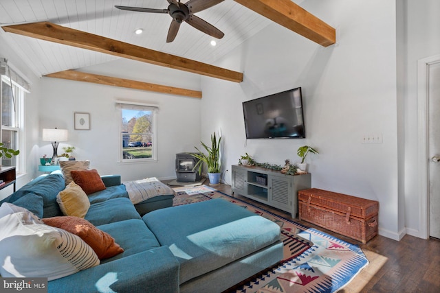 living room with dark hardwood / wood-style flooring, a wood stove, a wealth of natural light, and ceiling fan