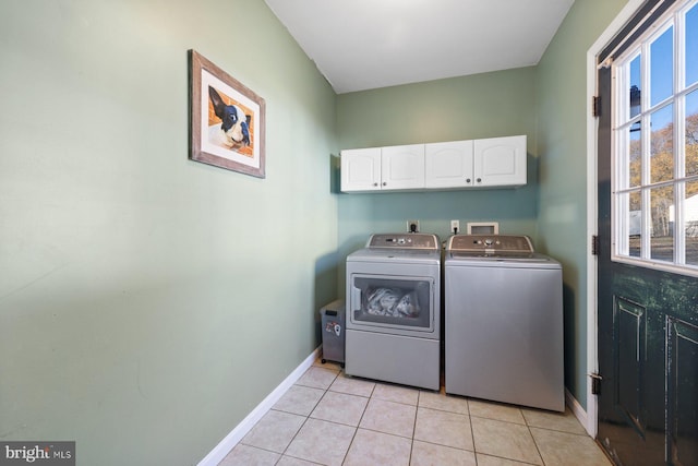 washroom featuring washer and clothes dryer, light tile patterned flooring, and cabinets