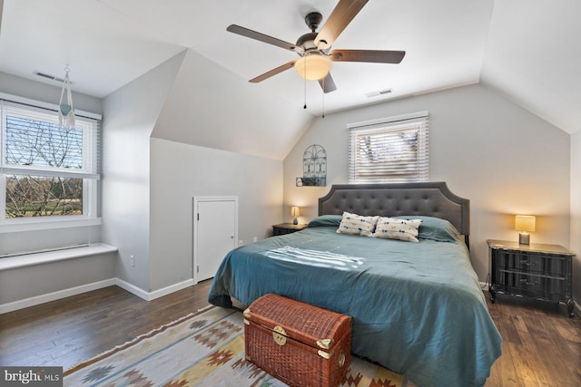 bedroom featuring ceiling fan, vaulted ceiling, dark wood-type flooring, and multiple windows