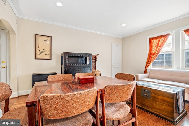 dining space with light wood-type flooring and ornamental molding