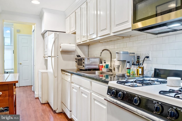 kitchen featuring white cabinetry, backsplash, light wood-type flooring, white appliances, and ornamental molding