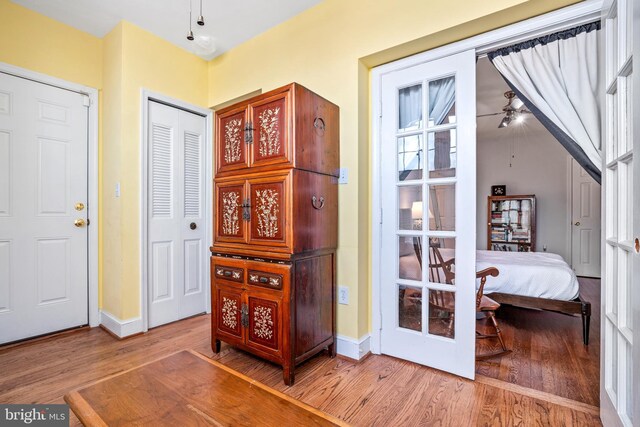 interior space with wood-type flooring, french doors, and ceiling fan