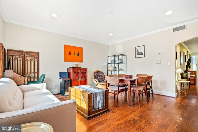 living room featuring wood-type flooring and ornamental molding