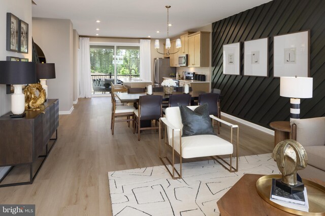 living room with light hardwood / wood-style floors and an inviting chandelier