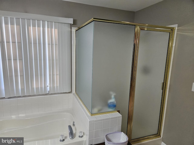 bathroom featuring shower with separate bathtub