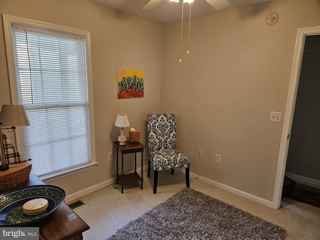 sitting room with ceiling fan and light colored carpet