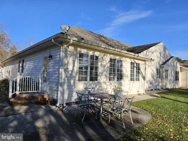 back of house with a patio area and a yard