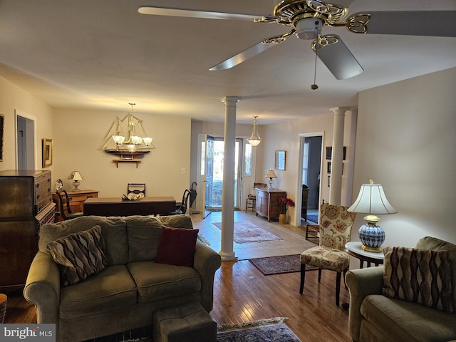 living room with ceiling fan with notable chandelier, light wood-type flooring, and decorative columns