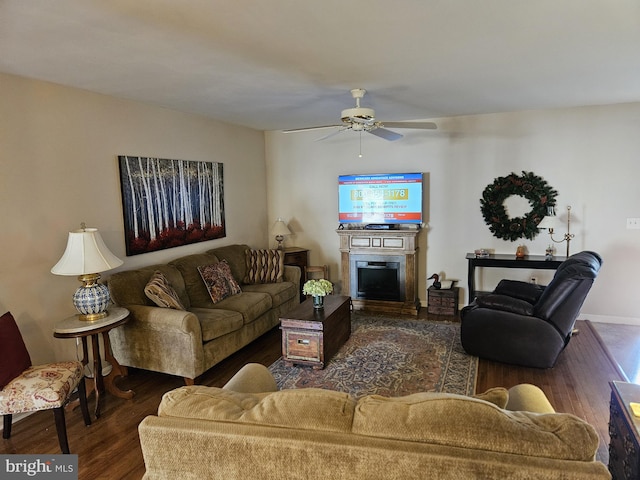 living room featuring ceiling fan and dark wood-type flooring