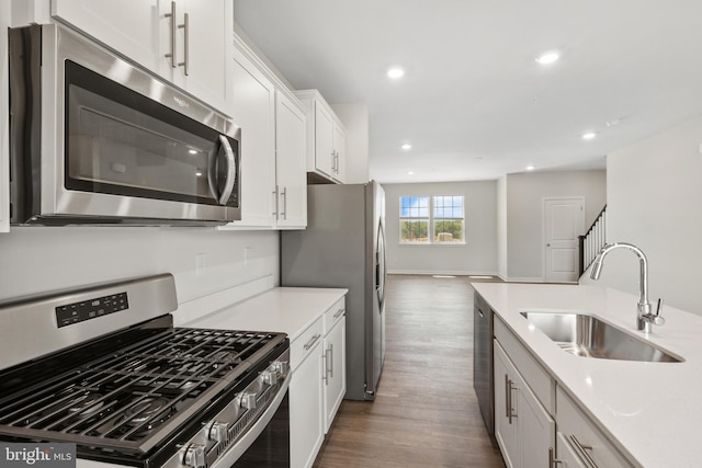 kitchen with dark hardwood / wood-style flooring, white cabinetry, sink, and appliances with stainless steel finishes