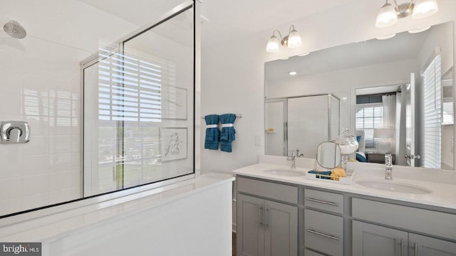 bathroom with a chandelier, vanity, and walk in shower