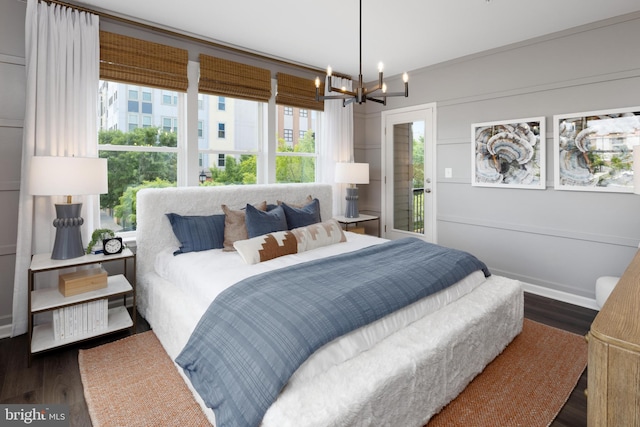 bedroom with wood finished floors, a chandelier, and multiple windows