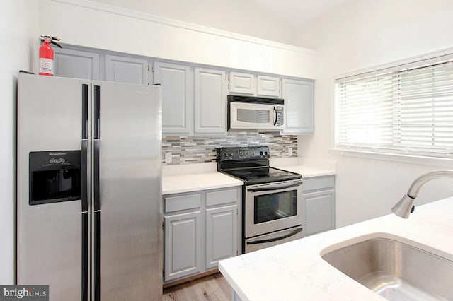 kitchen with gray cabinets, sink, and appliances with stainless steel finishes