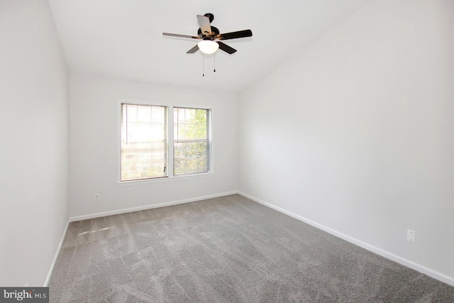 carpeted empty room featuring vaulted ceiling and ceiling fan