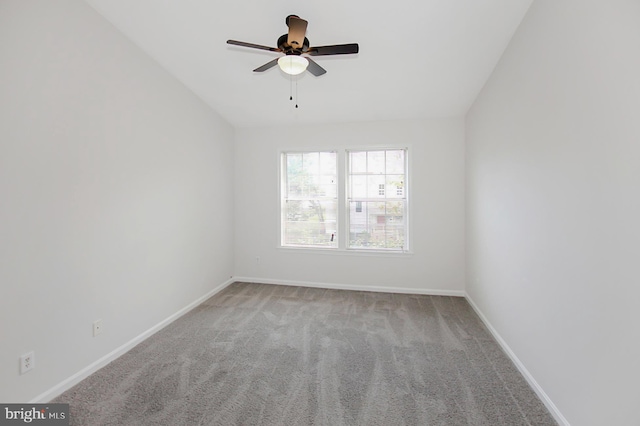 spare room with ceiling fan, light carpet, and vaulted ceiling