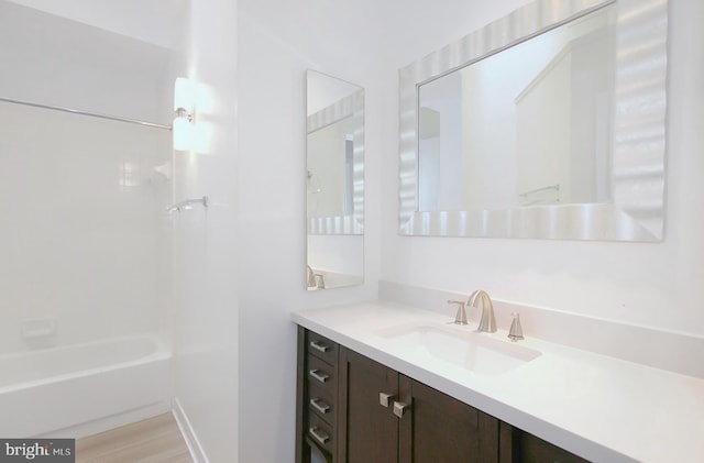 bathroom with hardwood / wood-style flooring, vanity, and bathtub / shower combination