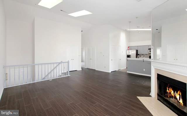 unfurnished living room featuring dark hardwood / wood-style floors and high vaulted ceiling