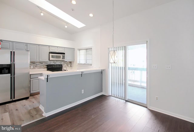 kitchen featuring gray cabinets, stainless steel fridge with ice dispenser, hardwood / wood-style floors, and decorative light fixtures