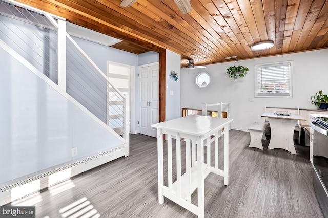 dining area featuring hardwood / wood-style flooring, wooden ceiling, ornamental molding, and a baseboard heating unit