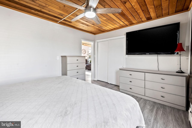 bedroom featuring ceiling fan, a closet, wood-type flooring, and wooden ceiling