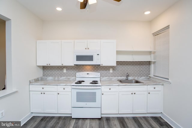 kitchen with sink, white cabinets, dark hardwood / wood-style floors, and white appliances