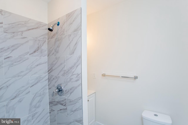 bathroom with toilet and a tile shower