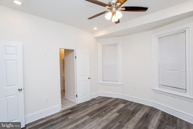 unfurnished room with ceiling fan and dark hardwood / wood-style flooring