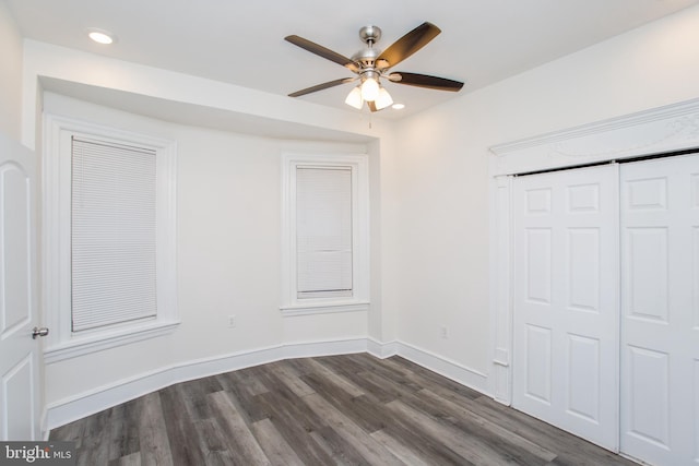 unfurnished bedroom with dark hardwood / wood-style flooring, a closet, and ceiling fan