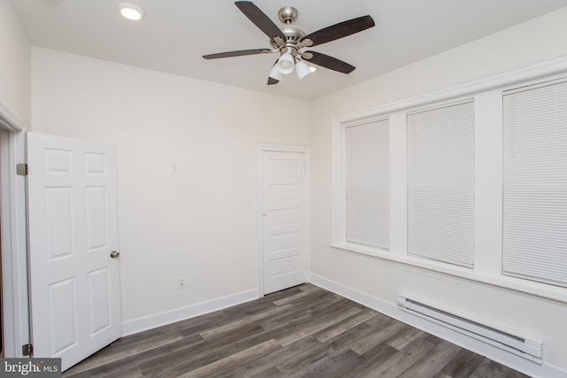 unfurnished bedroom with dark hardwood / wood-style flooring, ceiling fan, and a baseboard heating unit