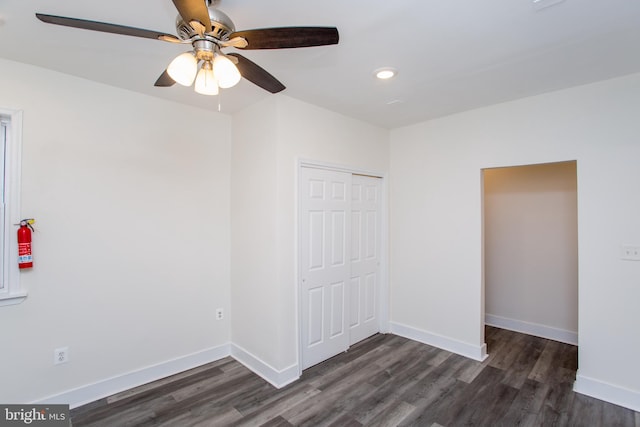 unfurnished bedroom with a closet, ceiling fan, and dark wood-type flooring