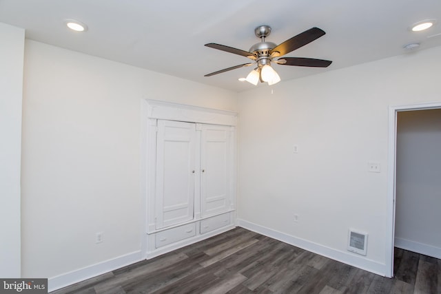 unfurnished bedroom featuring ceiling fan, a closet, and dark wood-type flooring