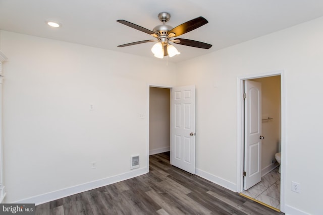 unfurnished bedroom with ceiling fan, dark hardwood / wood-style flooring, and ensuite bath