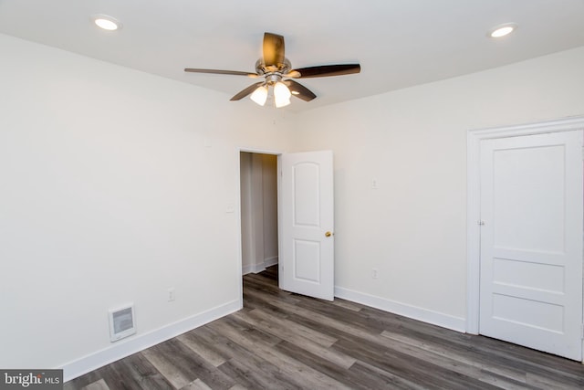 spare room with dark hardwood / wood-style floors and ceiling fan