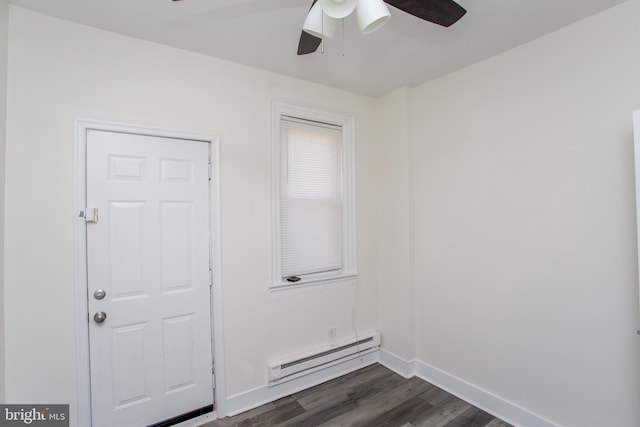 empty room with ceiling fan, dark hardwood / wood-style floors, and a baseboard heating unit