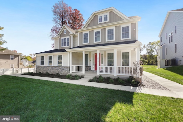 view of front of house with a front lawn, covered porch, and central AC