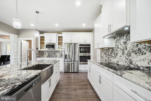 kitchen with white cabinets, sink, dark hardwood / wood-style floors, decorative light fixtures, and stainless steel appliances