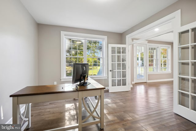 home office featuring plenty of natural light, dark hardwood / wood-style flooring, and french doors