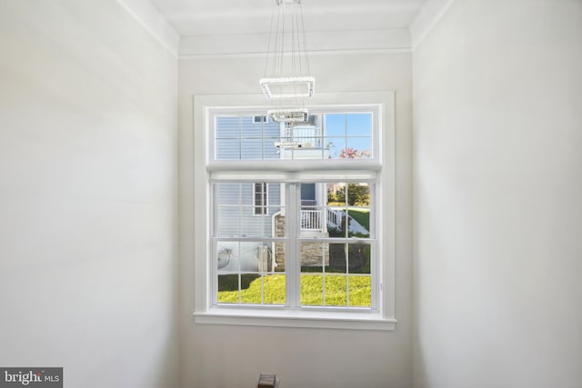 interior details with crown molding and an inviting chandelier