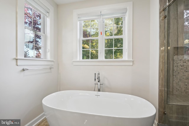 bathroom featuring shower with separate bathtub