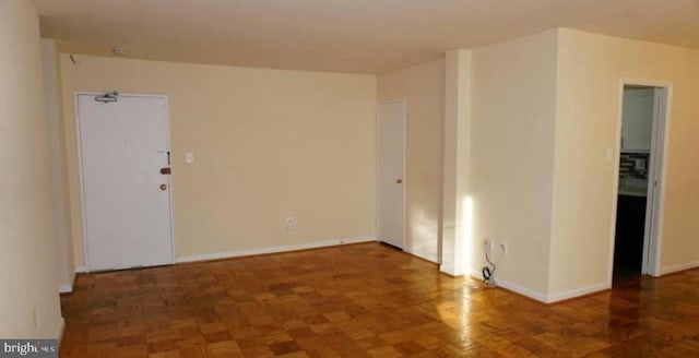 unfurnished room with dark parquet flooring