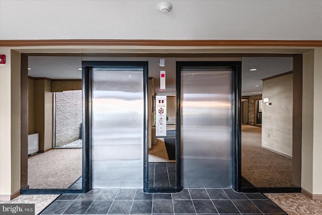 kitchen with elevator and dark carpet