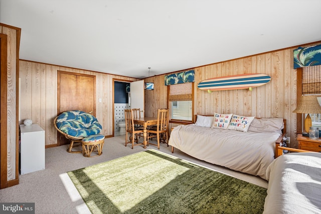 bedroom with wooden walls and light carpet