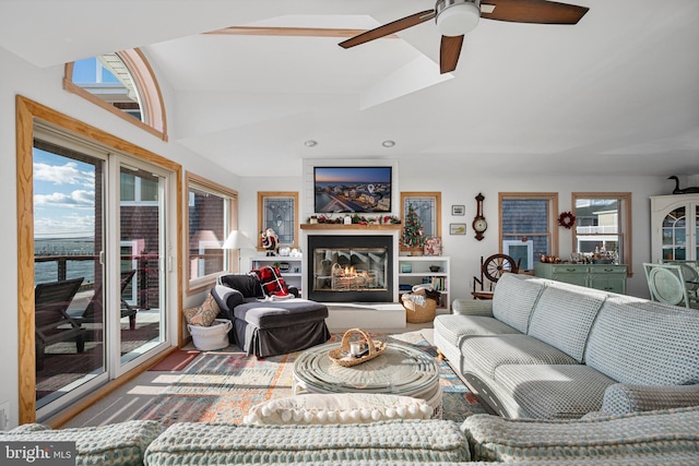 living room featuring plenty of natural light, ceiling fan, a water view, and vaulted ceiling