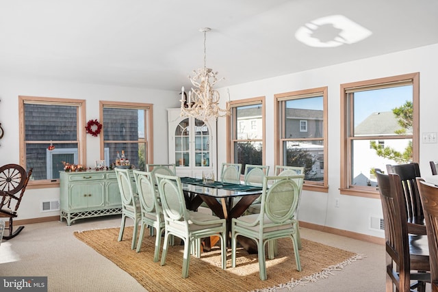 dining room with light carpet and an inviting chandelier