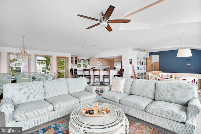 living room with ceiling fan with notable chandelier