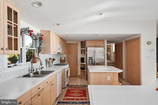 kitchen with light brown cabinets, a center island, sink, vaulted ceiling, and white appliances