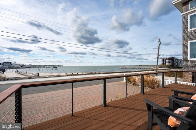 wooden deck with a view of the beach and a water view